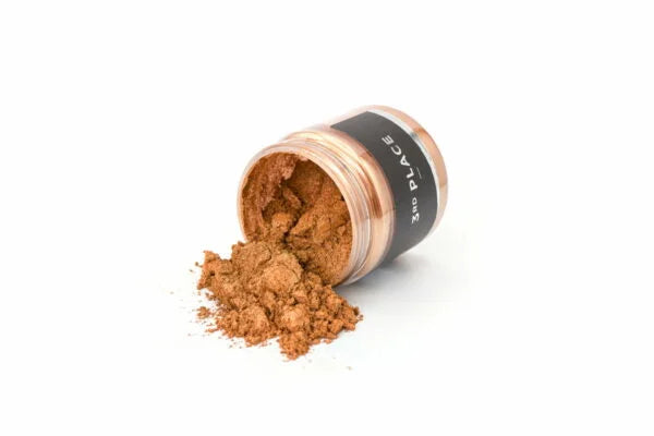 Bronze metallic mica pigmentpulver drysset ud fra en åben klar krukke med sort label.