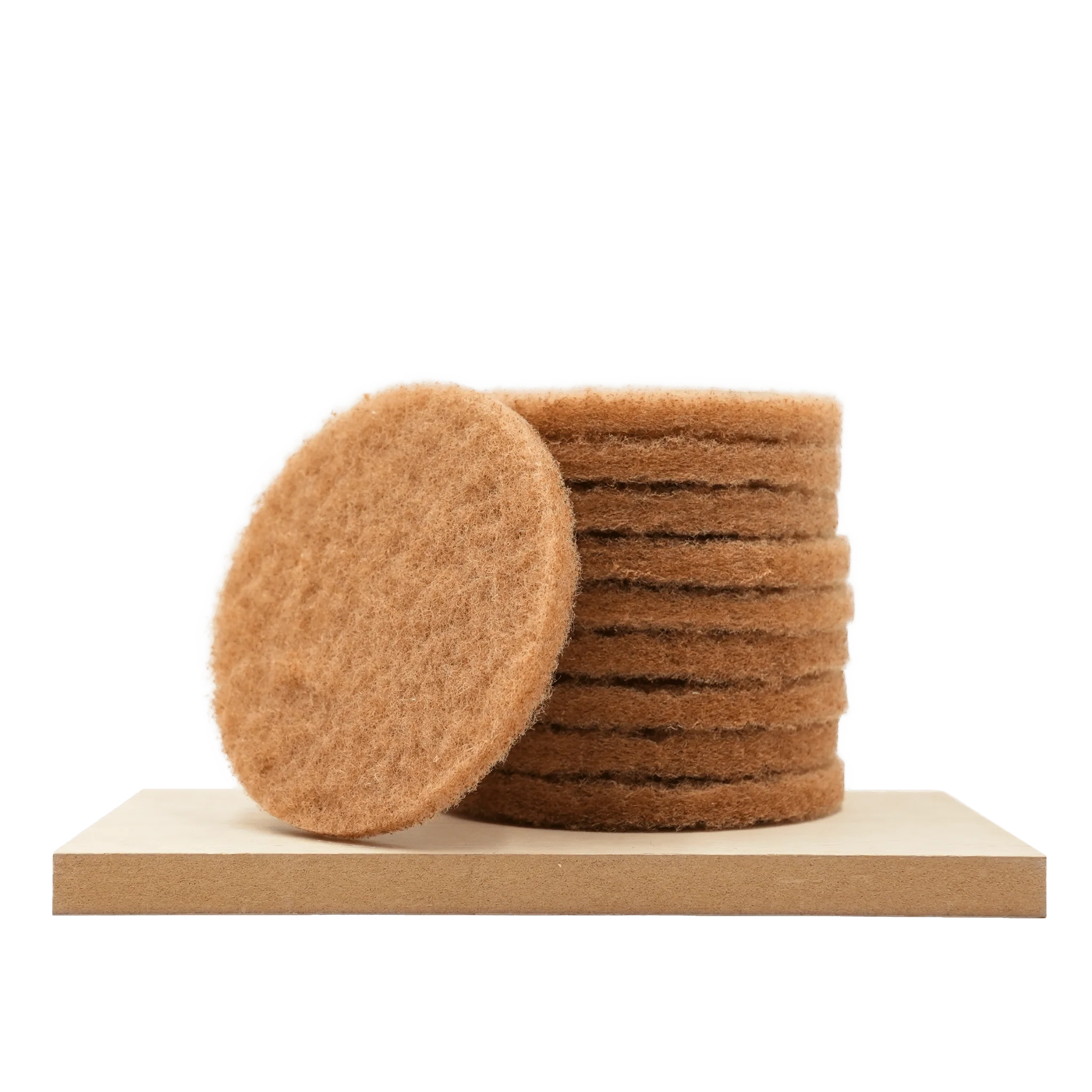 Stak af runde beige påføringspads i filtmateriale til træolie, en pad fremme og flere stablet bagved på lysebrunt underlag.