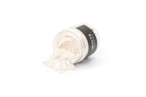 Elfenbenfarvet mica pigmentpulver spredt ud fra sortbåret krukke med label.